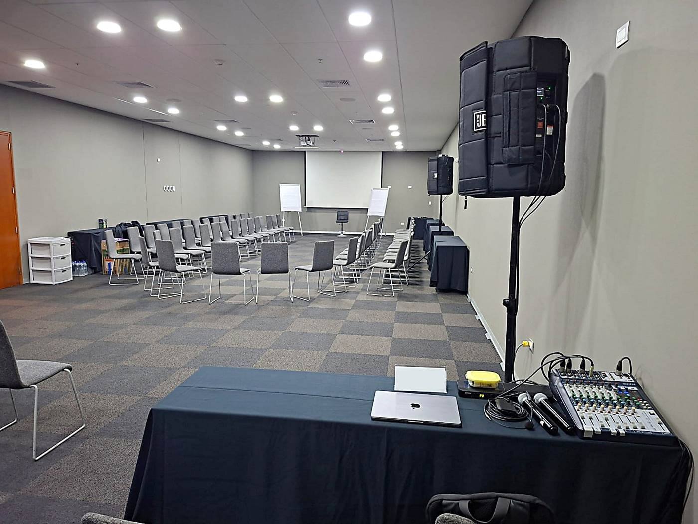 Parlante en trípode, consola de sonido y micrófonos inalámbricos listos para una capacitación en un salón de eventos en Lima