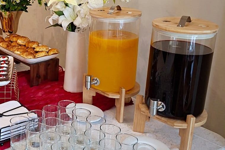 Estación de bebidas con jugo natural y refresco en dispensadores, con vasos, para un evento en Lima