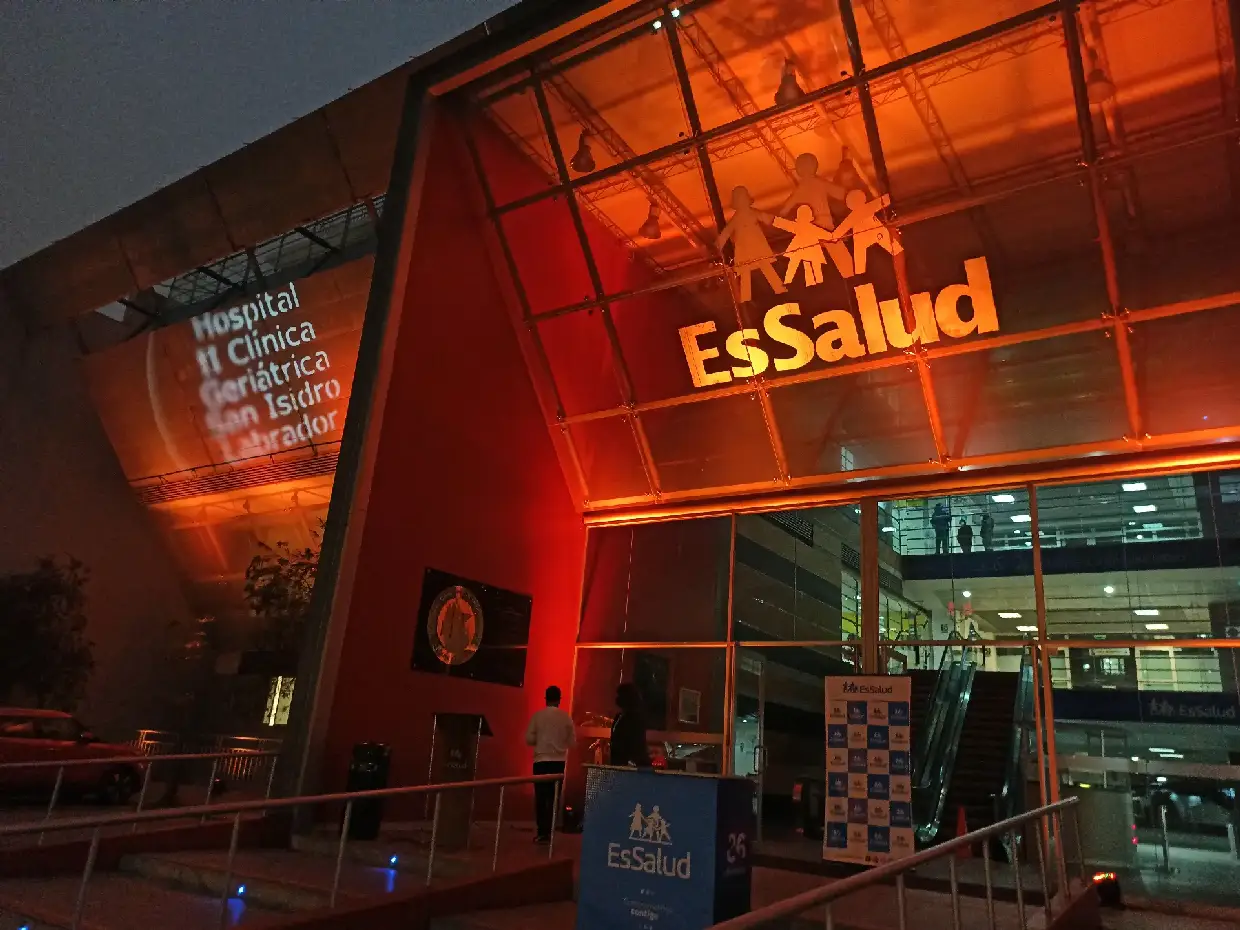 Fachada de EsSalud iluminada en naranja y rojo con luces LED para un evento