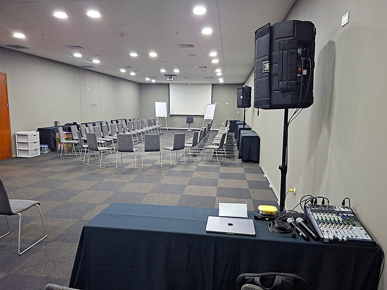 Parlantes, consola de sonido, micrófonos y ecran listos en una sala de capacitación: servicio audiovisual para eventos en Lima