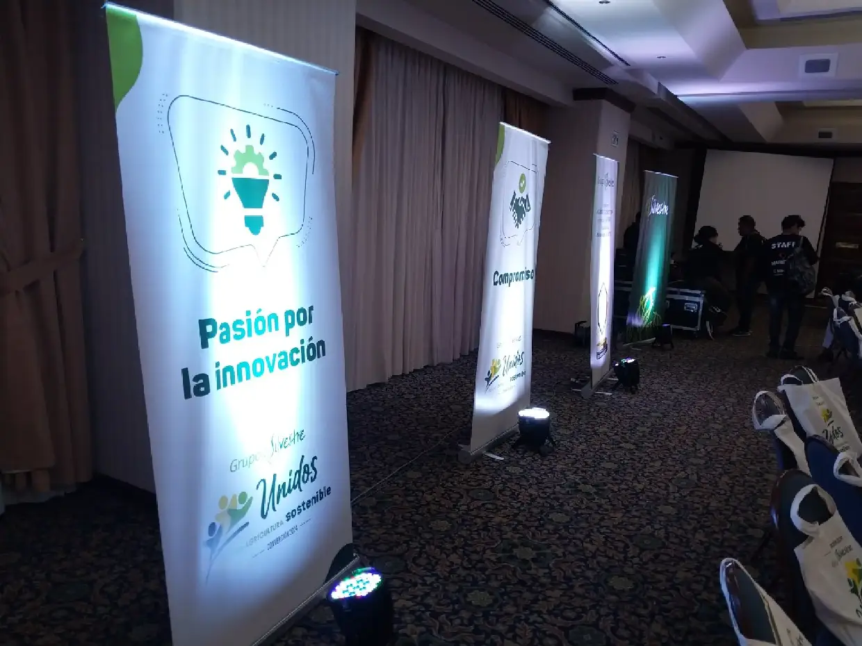 Banners de un evento corporativo iluminados desde el piso con tachos PAR LED